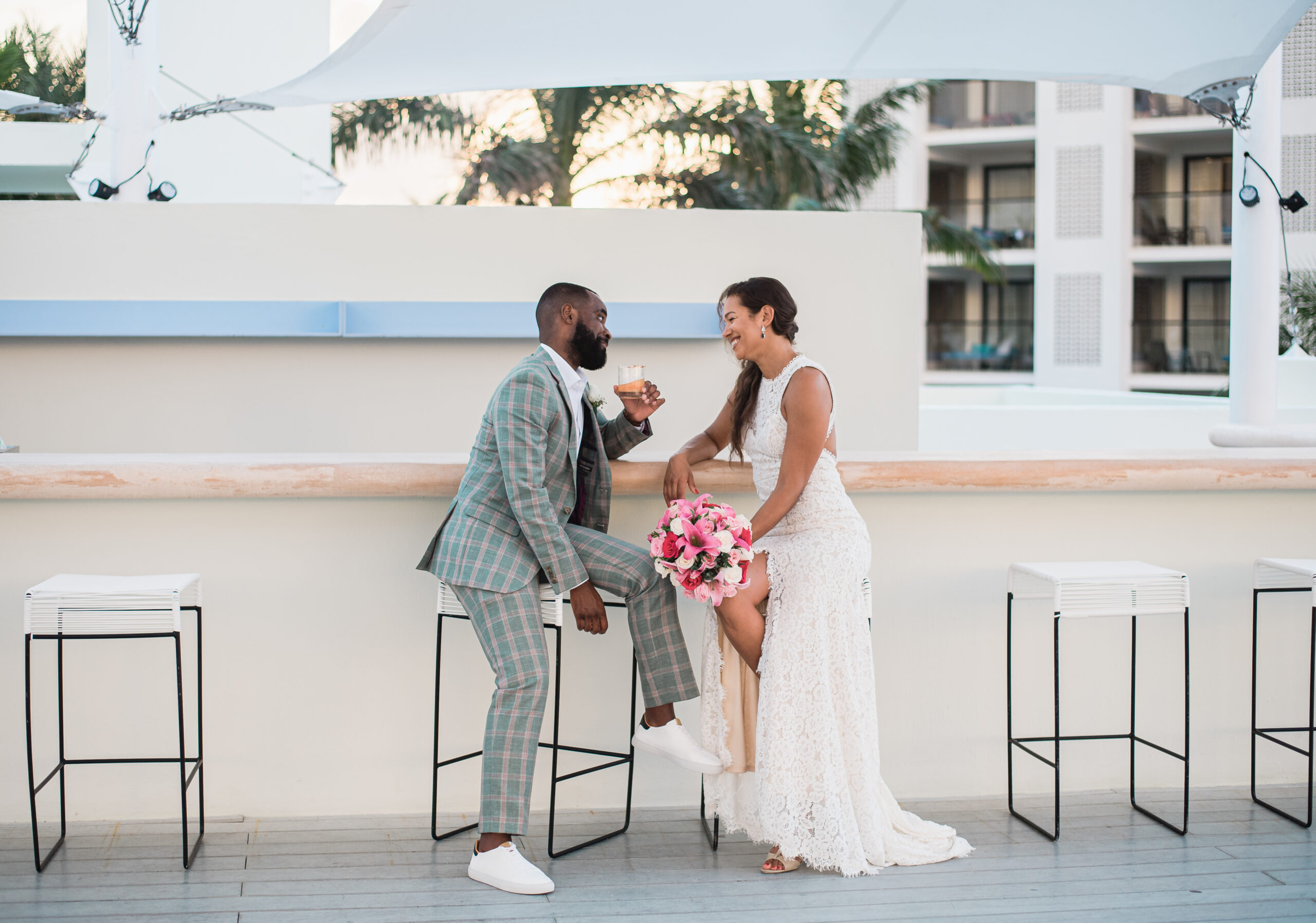 St. Julien Hotel Wedding couple sits at the bar and share a drink together while looking at each other