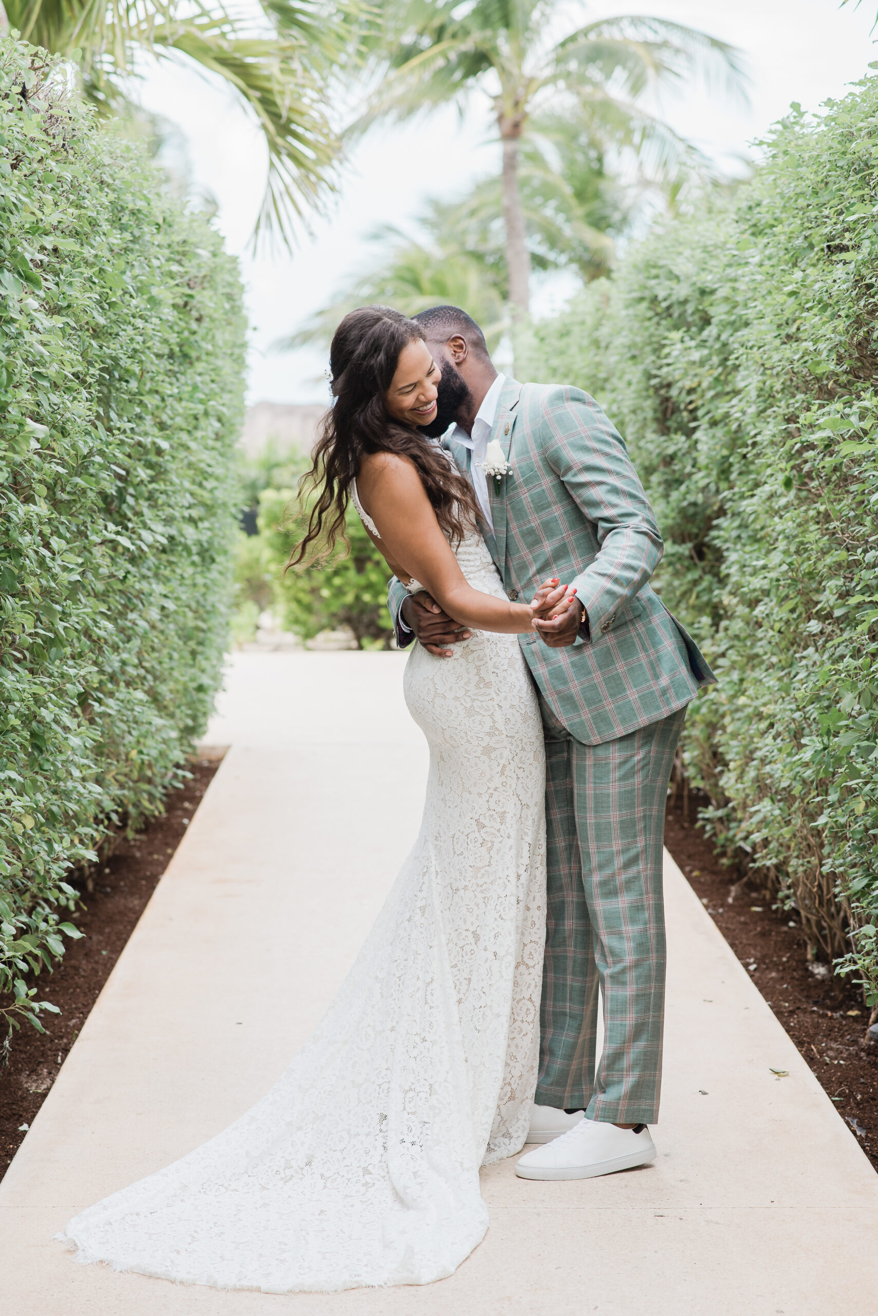 A couple at a St. Julien Hotel Wedding getting married snuggle as the groom nuzzles into the bride's neck and smile