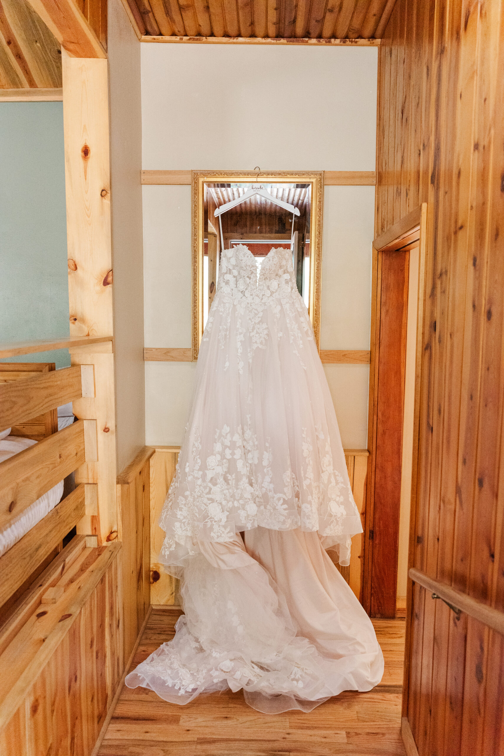 A detail shot of a wedding dress hanging off a mirror in the house at a flagstaff house wedding