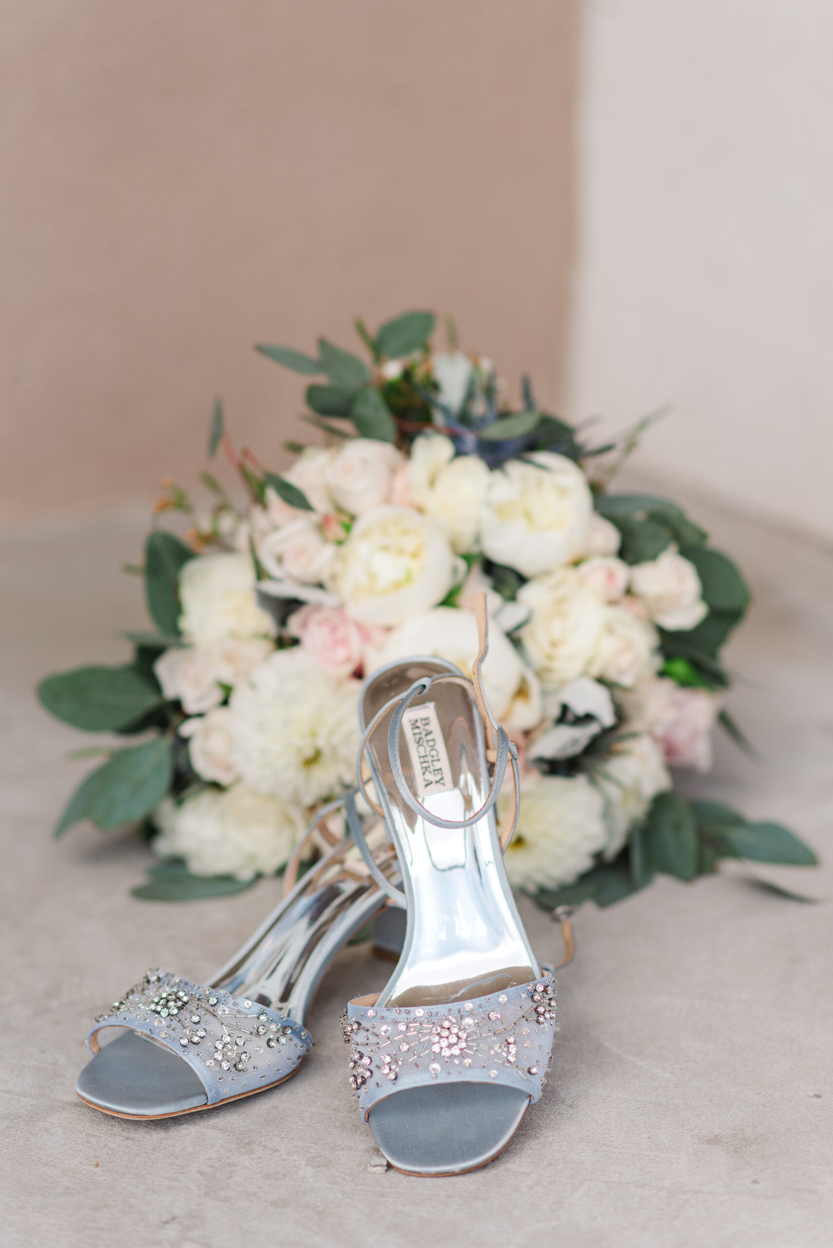 Detail photos of a bouquet with pink and white roses with shoes in the front of the bouquet