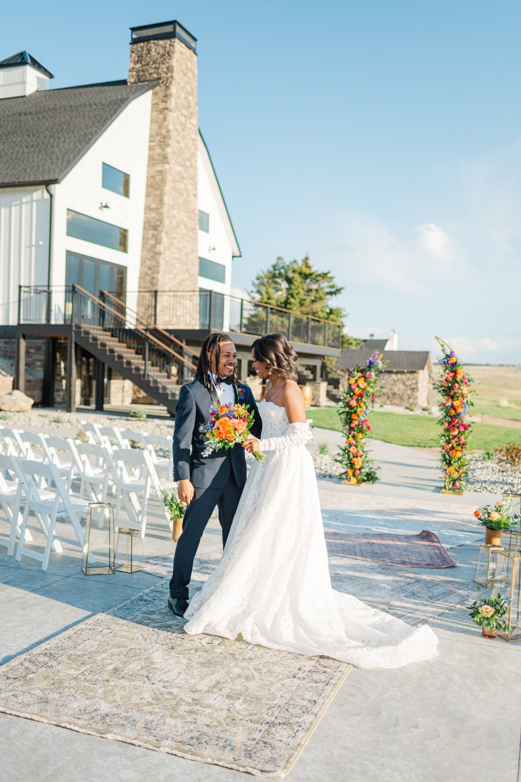 A couple holds hands and smiles at each other at their ceremony site at cherry valley venue